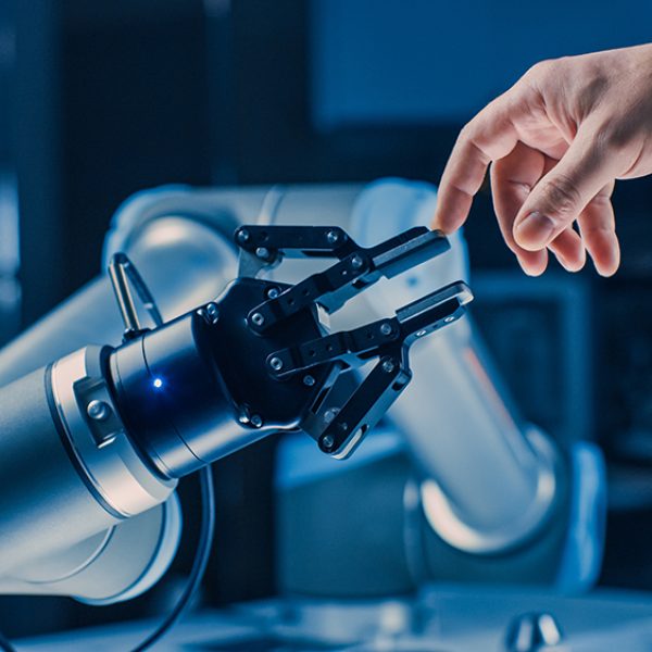 Futuristic Robot Arm Touches Human Hand in Humanity and Artificial Intelligence Unifying Gesture. Conscious Technology Meets Humanity. Concept Inspired by Michelangelo's Creation of Adam